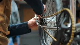 mecanico de bicicletas montando una cadena de bicicleta