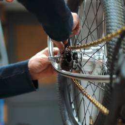 mecanico de bicicletas montando una cadena de bicicleta