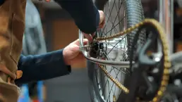 Detalle en primer plano de un artesano trabajando en una bicicleta en el taller de Kekosa, como parte de la estrategia de creación de contenido producida por LUP Studio.