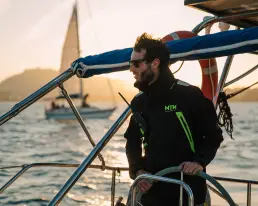 Persona navegando con equipación NTN Ocean Wear en un atardecer, como parte del contenido digital ecommerce creado por LUP Studio.