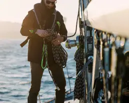 Persona trabajando con cabos a bordo de un velero vistiendo ropa técnica de NTN Ocean Wear, ejemplo de contenido digital ecommerce producido por LUP Studio.