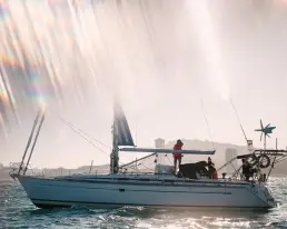 Un velero navegando en el mar durante un atardecer con efectos de luz natural, utilizado en la campaña de contenido digital para la marca de ropa náutica NTN Ocean Wear.